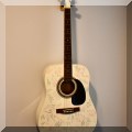 M06. White acoustic guitar signed by various family and friends. 